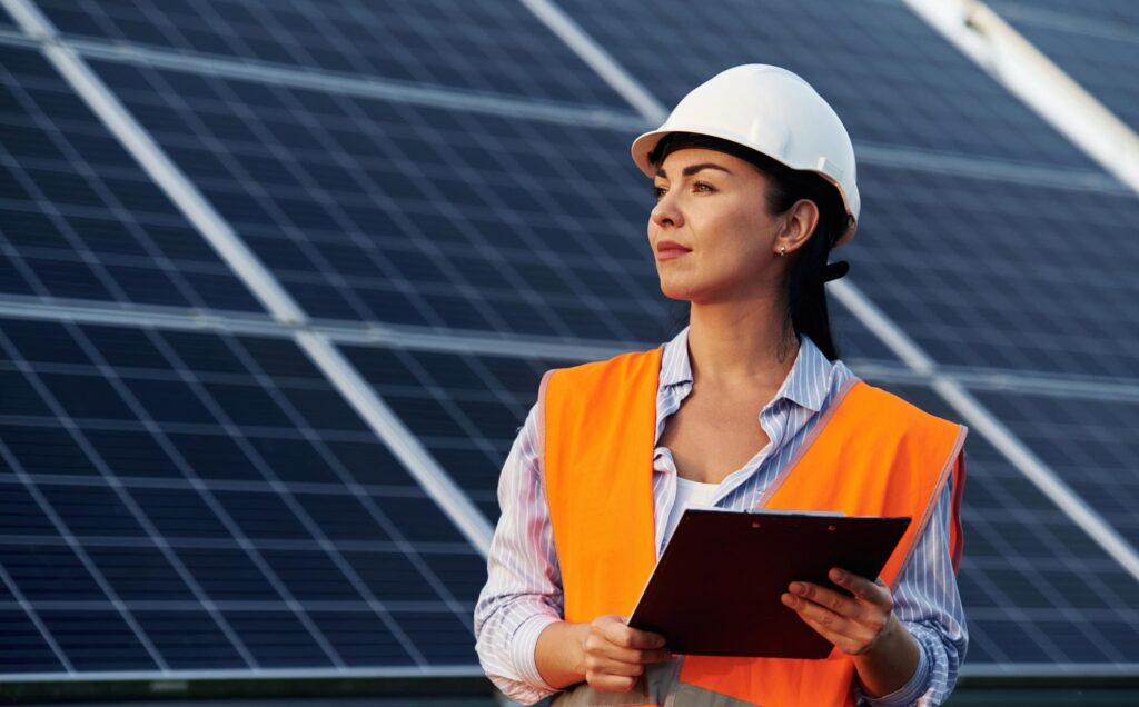 Female solar energy engineer conducting solar project inspection at a renewable energy power plant